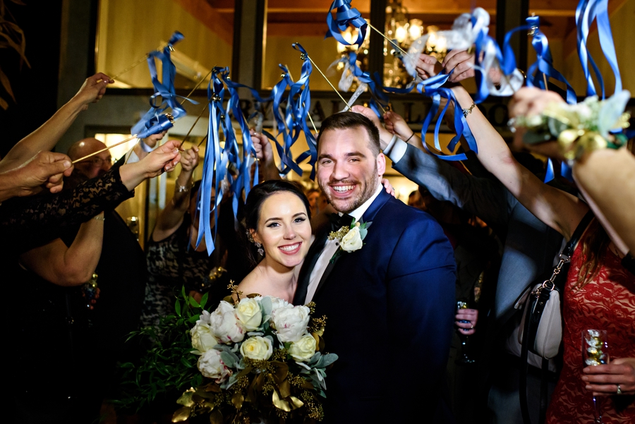 Wedding guests shake ribbons as the bride and groom run out of thier reception at the end of the night.